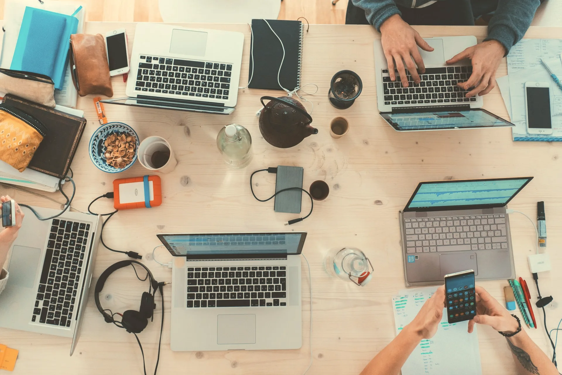 A team working across laptops at one shared desk